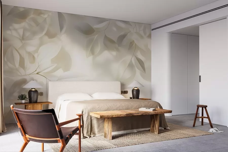 Carta da parati nature Rami bianchi appesi con foglie contro una parete con luce solare 