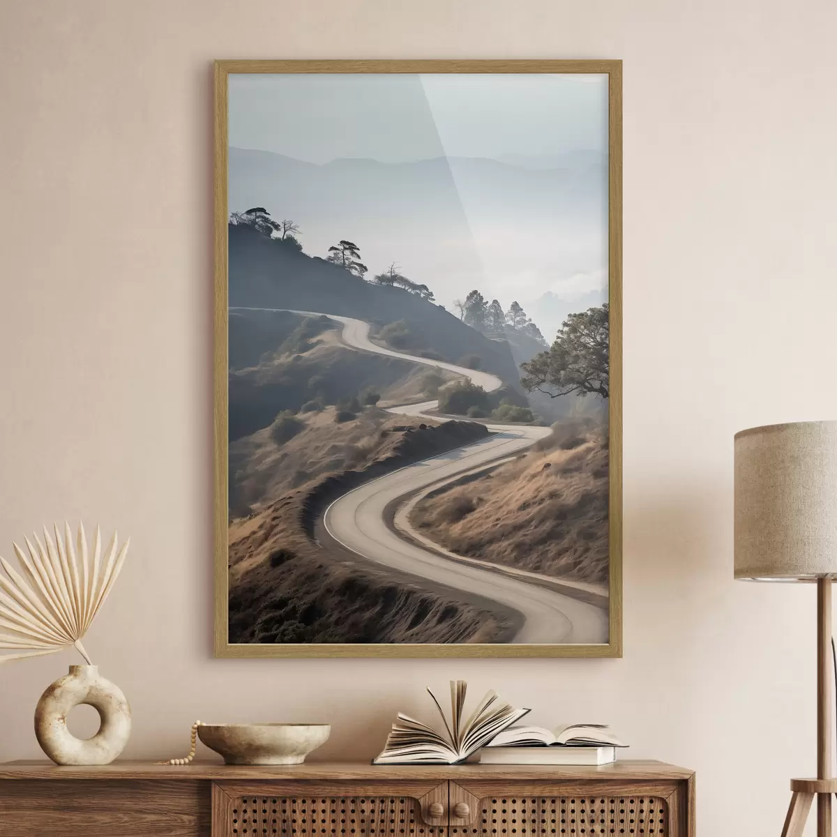 Poster Una strada tortuosa che attraversa un paesaggio collinare con erba secca sotto un cielo limpido e montagne in lontananza f46289